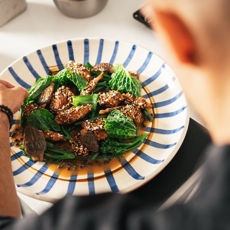 Striped plate with sesame-coated meat and greens