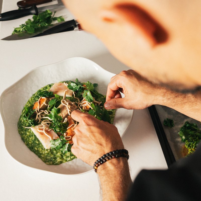 Chef plating green risotto